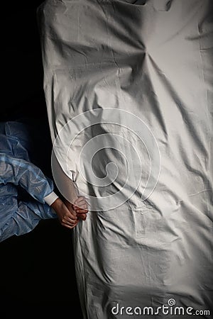 Female health worker holds the dead patient by hand, concept of death in the hospital Stock Photo