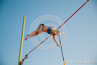 Female high jumper training at the stadium in sunny day Stock Photo