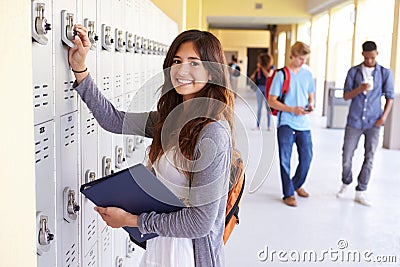 Female High School Student Opening Locker Stock Photo