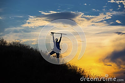Female hiker silhouette with massive clouds on the Stock Photo