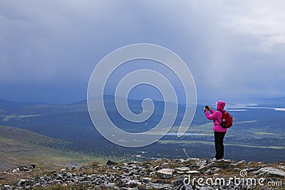 Female hiker taking mobile phone photo on fell top Stock Photo