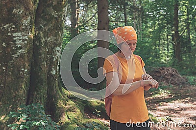 Female hiker using smart wristband during trekking in nature Stock Photo