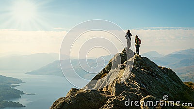 Female hikers on top of the mountain enjoying valley view Stock Photo