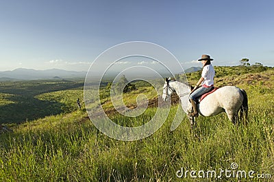 Female horseback rider and horse ride overlooking Lewa Wildlife Conservancy in North Kenya, Africa Editorial Stock Photo