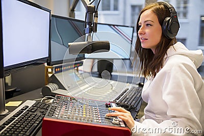 Female Host Using Control Panel At Radio Station Stock Photo