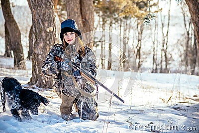 Female hunter in camouflage clothes ready to hunt, holding gun a Stock Photo