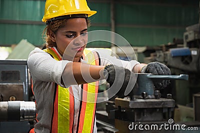 Female industrial worker working and checking machine in a large industrial factory with many equipment Stock Photo