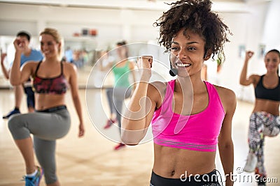 Female instructor with headset in fitness class Stock Photo