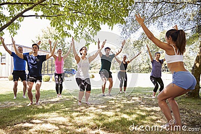 Female Instructor Leading Outdoor Yoga Class Stock Photo