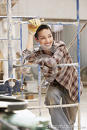 Female interior decorator leaning on Scaffolding Stock Photo