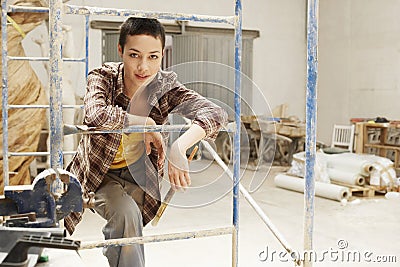 Female interior decorator leaning on Scaffolding portrait Stock Photo