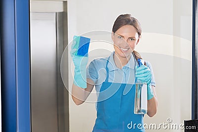 Female Janitor Cleaning Glass Stock Photo