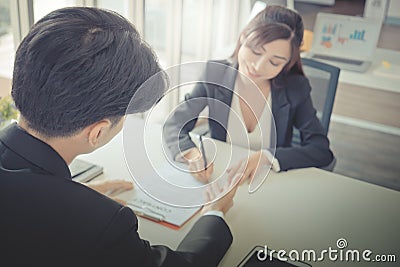 Female job candidate signing work contract with HR officer after a successful job interview Stock Photo