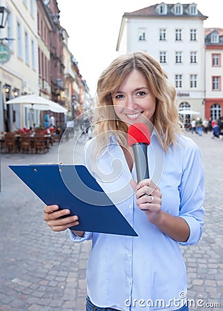 Female journalist with microphone in the city Stock Photo
