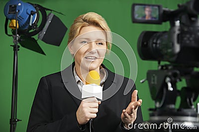 Female Journalist Presenting Report In Television Studio Stock Photo