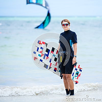 Female kiteboarder carrying her board Stock Photo