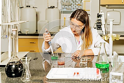 Female laboratory technician researching medical samples and reagents for coronavirus vaccination Stock Photo