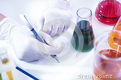 Female Laboratory Worker Dealing With Flasks Containing Liquid Chemicals Stock Photo