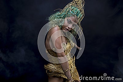 Female Latin woman with green hair and gold costume with handmade flourishes, fantasy image and tale Stock Photo