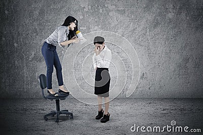 Female leader shouting to her employee Stock Photo