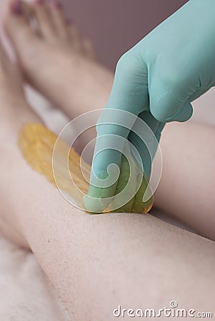 Female legs depilation with sugar pasta. Beauty Cosmetic Procedure for Girls. Stock Photo