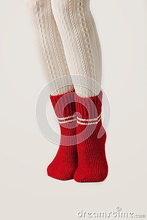 Female legs in white stockings and red knit socks. Stock Photo