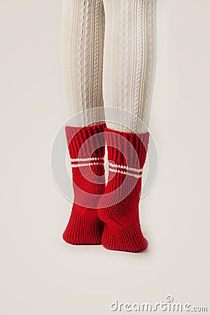 Female legs in white stockings and red knit socks. Stock Photo