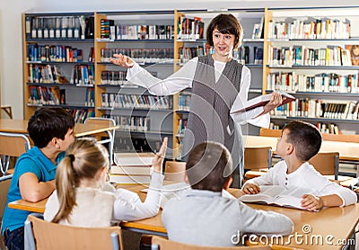 Female librarian and schoolkids during classes Stock Photo