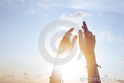 Female lifting hands up to sunset sky Stock Photo