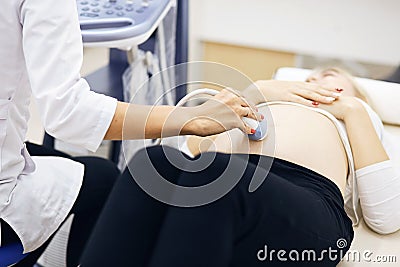 Female looking for a baby in the stomack with ultrasound device Stock Photo