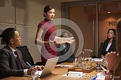 Female manager standing with documents at business meeting Stock Photo