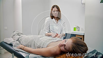 Female massage therapist massaging hands of her woman client Stock Photo