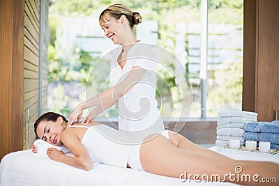 Female masseur massaging beautiful woman at spa Stock Photo