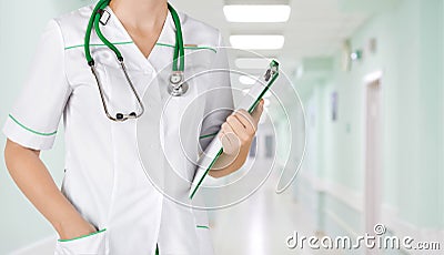 Female medical doctor with clipboard standing over blurry hospital background Stock Photo