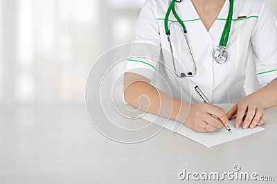 Female medical doctor with clipboard standing over blurry hospital background Stock Photo