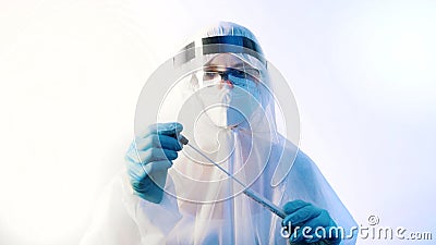 Female medical technician in protective suit taking nasal swab covid19 test from the patient Stock Photo