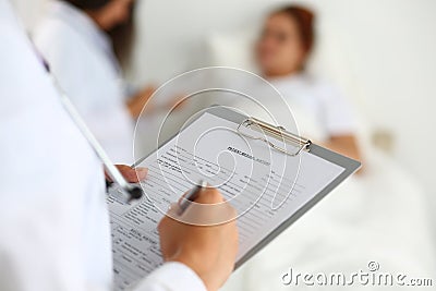 Female medicine doctor filling in patient medical history list Stock Photo