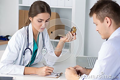 Female medicine doctor prescribing pills to her male patient Stock Photo