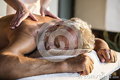 Female message therapist giving a massage at a spa Stock Photo