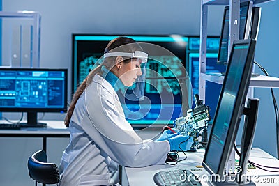 Female microelectronics engineer works in a scientific laboratory on computing systems and microprocessors. Professional Stock Photo