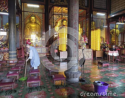 a female monk cleaning the temple floor Editorial Stock Photo