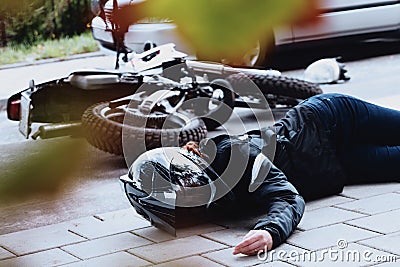 Female motorcyclist lying unconscious Stock Photo