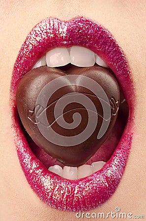 Female mouth with chocolate candy Stock Photo