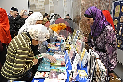 Female muslims buying religious book during celebrating Islamic holiday Mawlid Editorial Stock Photo