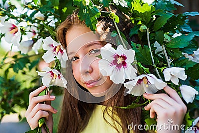 female natural beauty. cheerful pretty child at blooming tree outdoor. vacation time. summer fashion beauty. beautiful Stock Photo