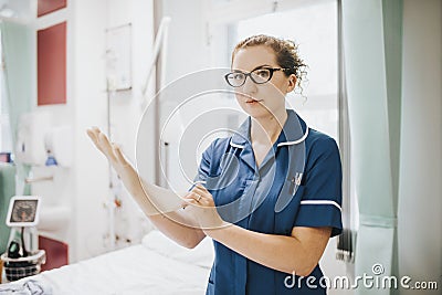 Female nurse putting on a glove Stock Photo