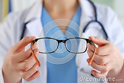 Female oculist doctor hands giving pair of glasses. Good vision Stock Photo