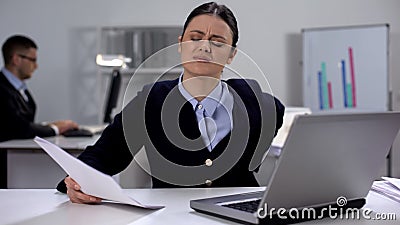 Female office manager feeling lower back pain on workplace, sedentary lifestyle Stock Photo