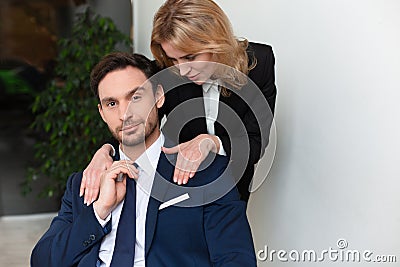 Female office worker seduces to male boss. Young woman stroking male shoulders. Women empowerment concept. Feminism Stock Photo