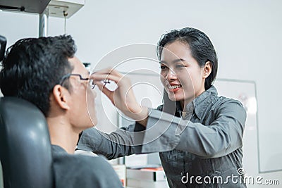 The female ophthalmologist applies the experimental frame to the patient Stock Photo